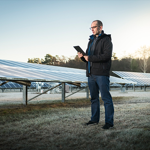 Man next to solar energy panels