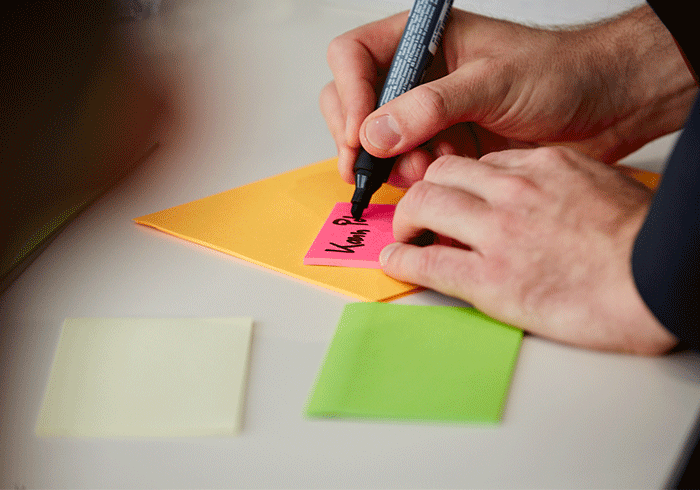 KIT Mann schreibt auf Post-it